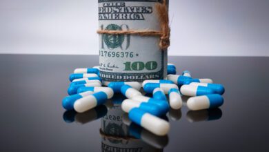 Banknotes and medicine with reflection on a black acrylic board