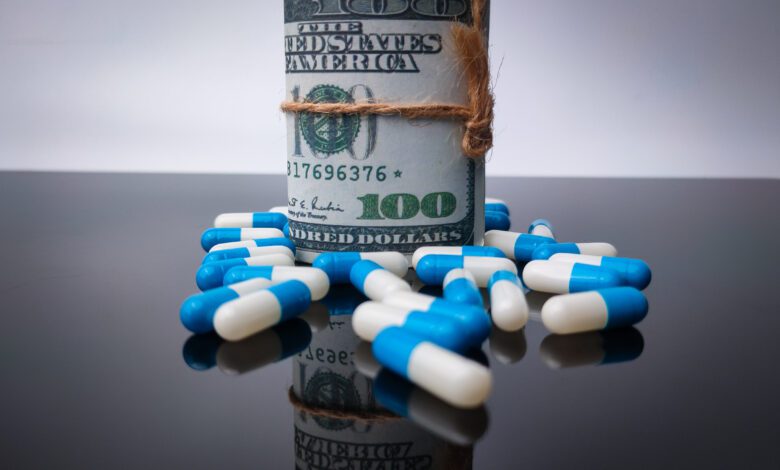 Banknotes and medicine with reflection on a black acrylic board